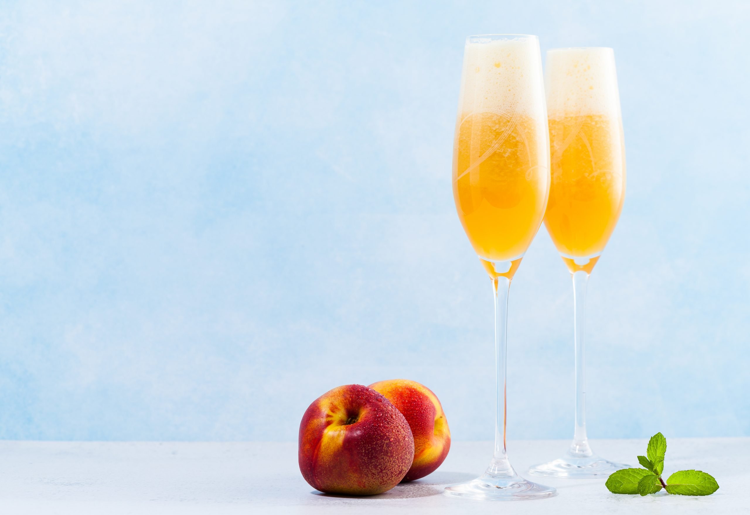 Two Bellini cocktails with fresh peaches, a classic Venetian sparkling toast