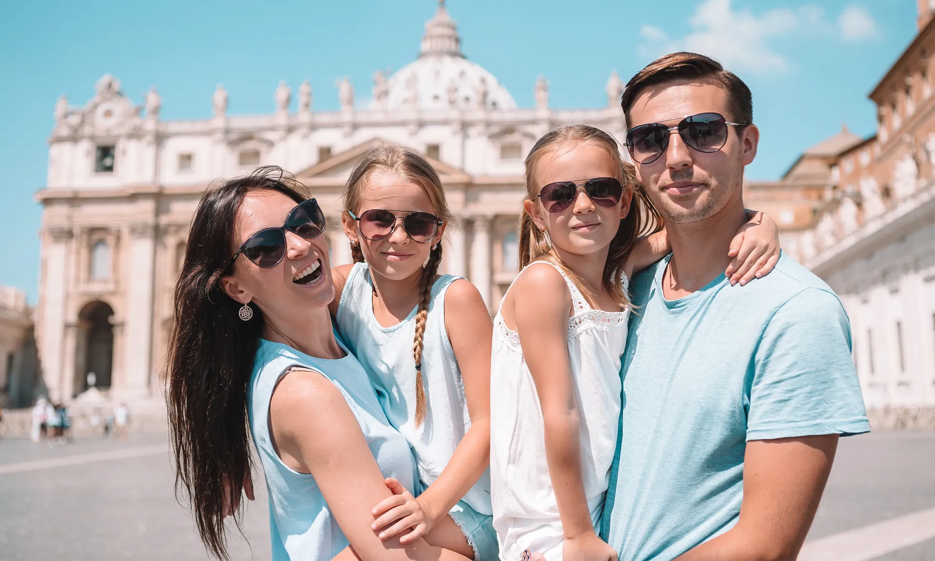 Family of four sightseeing in Saint Peter's Square in Rome, Italy