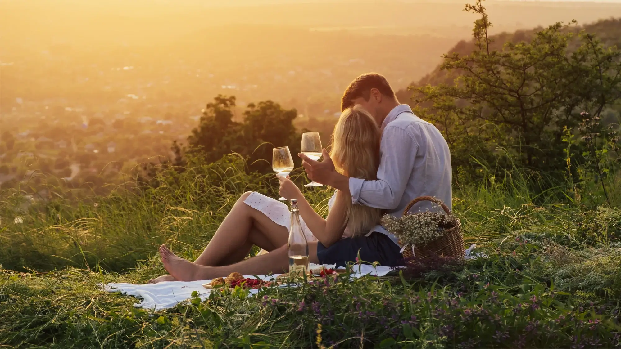 Couple sharing a glass of wine at sunset on an Italian hillside