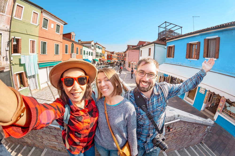 Young travelers among the painted houses of Burano, Veneto, Italy
