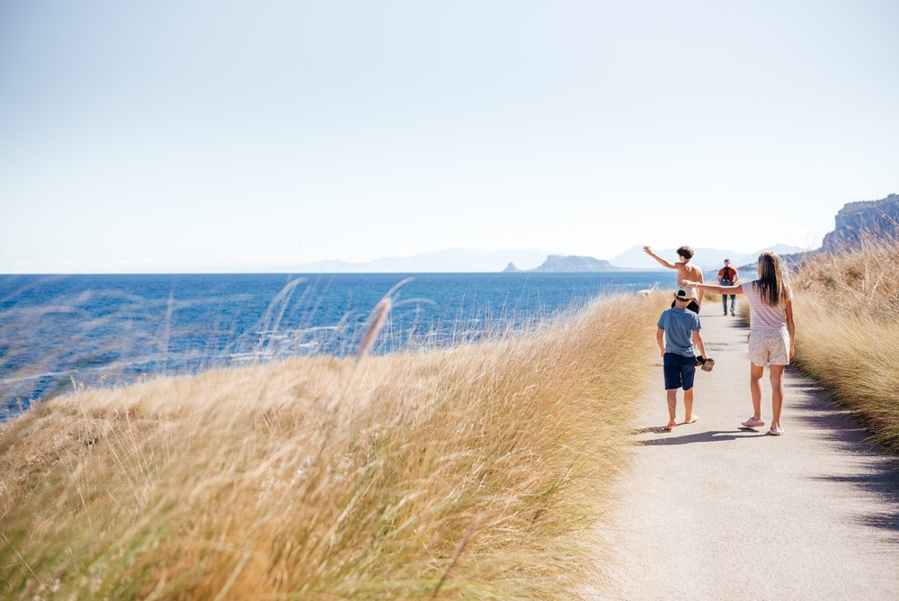 family walking coast in sicily