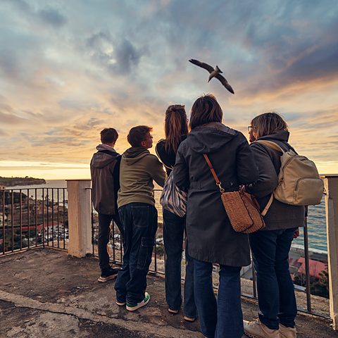 A family looking out over the seaside town of Gaeta at sunset, Lazio, Italy