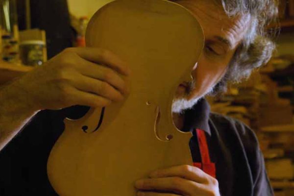 A master violin maker at work in his Cremona workshop, Lombardy, Italy