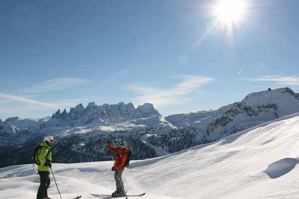 Skiers on a Dolomites panorama in Trentino, Italy