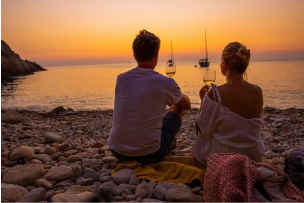 Couple watching the sunset over the Tuscan coast, Italy